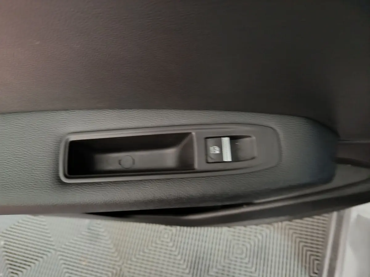 Gros plan sur la commande de lève-vitre côté conducteur dans une Renault Captur gris foncé 2024.