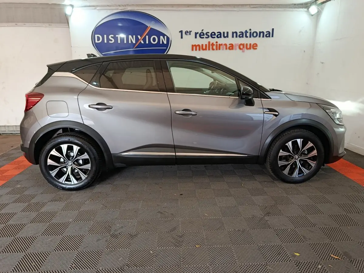 Profil côté gauche d'un Renault Captur techno TCe 90 gris foncé, avec jantes alliage et toit noir contrasté.