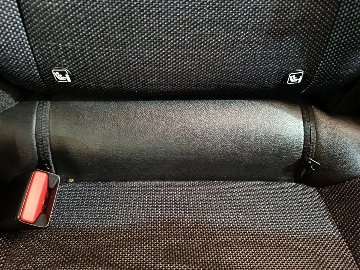 Gros plan sur la banquette arrière noire du Renault Captur 2024 avec attaches Isofix visibles et ceinture rouge.