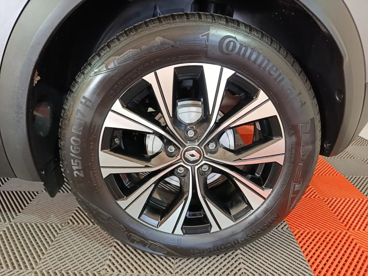 Gros plan sur la roue avant droite du Renault Captur gris foncé avec jante alliage noire et argentée design moderne.