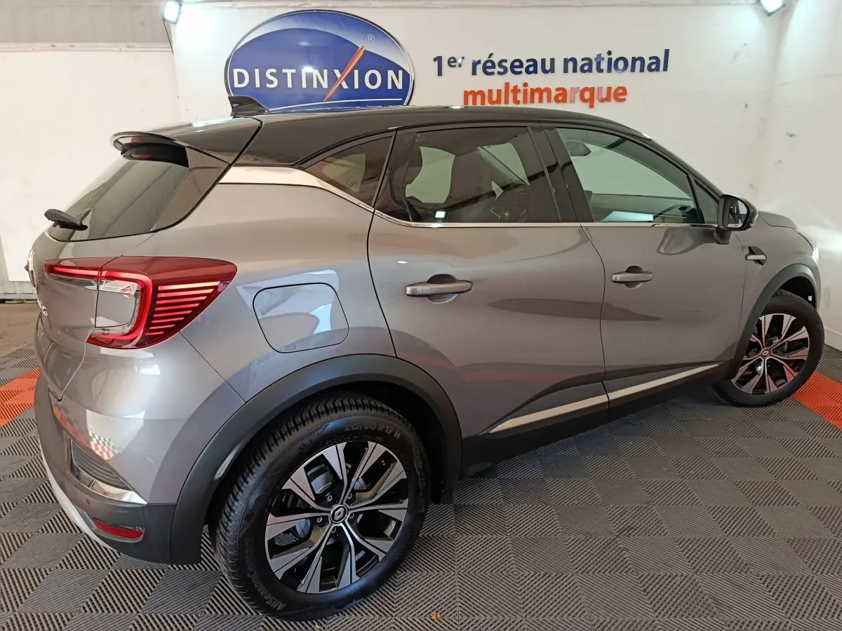 Renault Captur Techno TCe 90 gris foncé vu de profil côté droit, avec jantes alliage et feux arrière LED distinctifs.