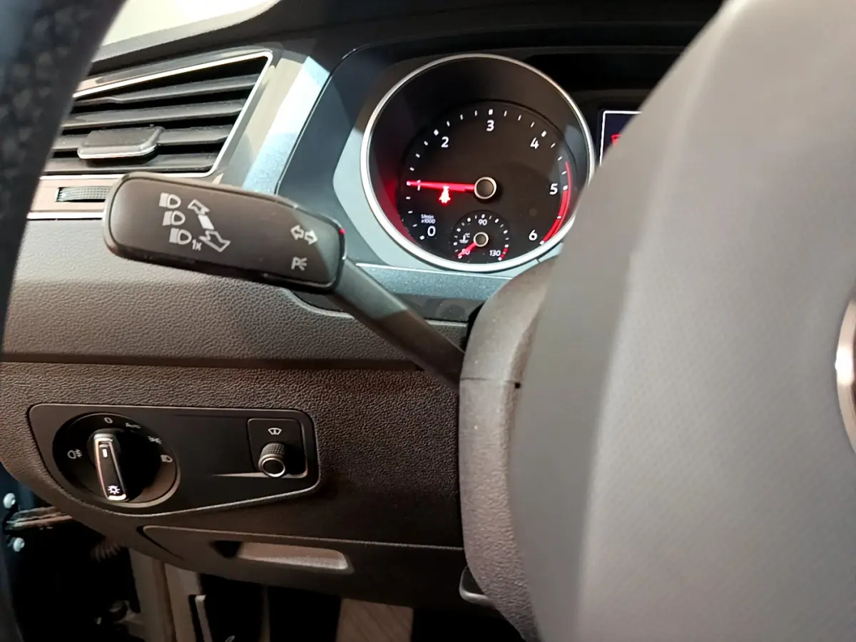 Vue rapprochée du tableau de bord gris clair du Volkswagen Tiguan 2021, avec manette de clignotants et compte-tours visible.