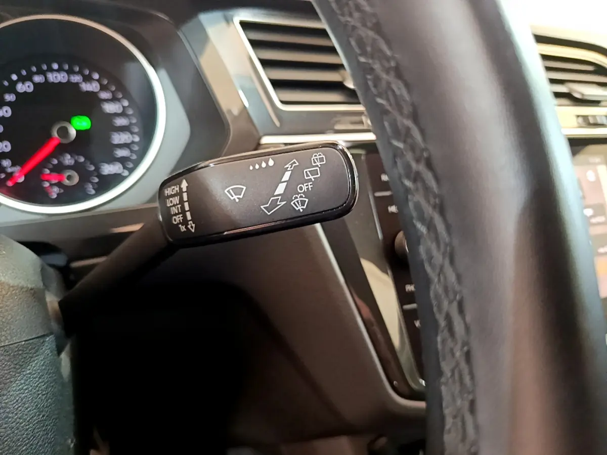 Le levier de commande des essuie-glaces du Volkswagen Tiguan gris clair, vu de près côté gauche du volant en cuir.