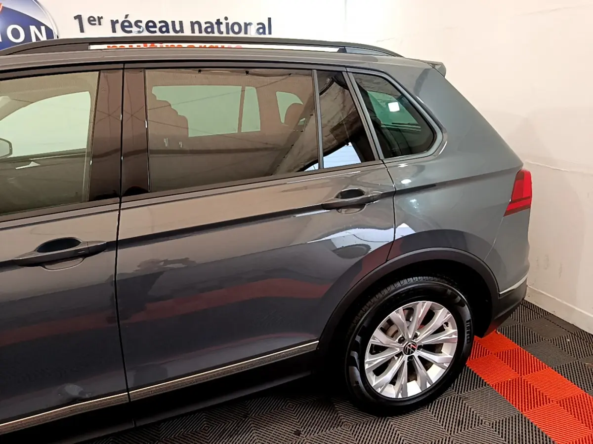 Vue côté droit arrière du Volkswagen Tiguan gris clair 2021 avec jante alliage et feux arrière LED visibles.