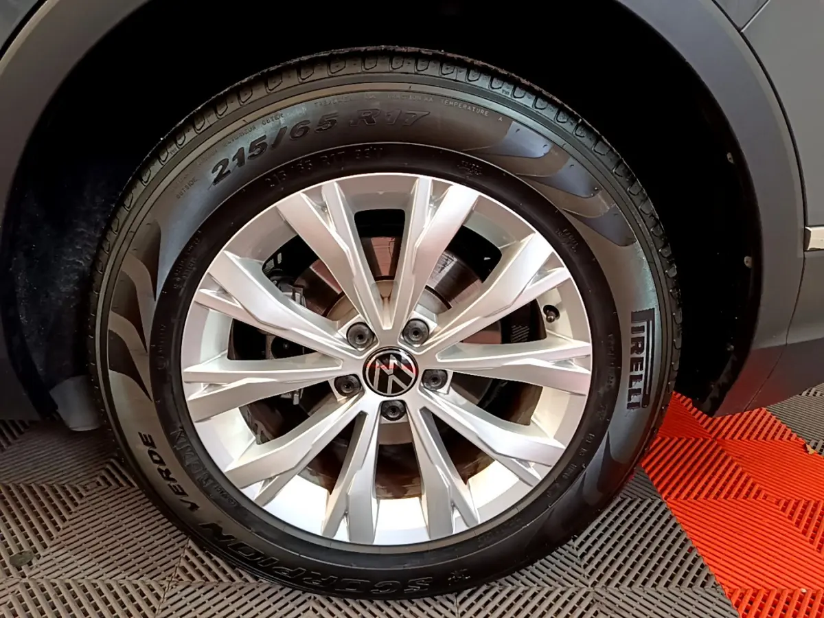 Gros plan sur la roue avant droite du Volkswagen Tiguan gris clair avec jante alliage et pneu Pirelli.