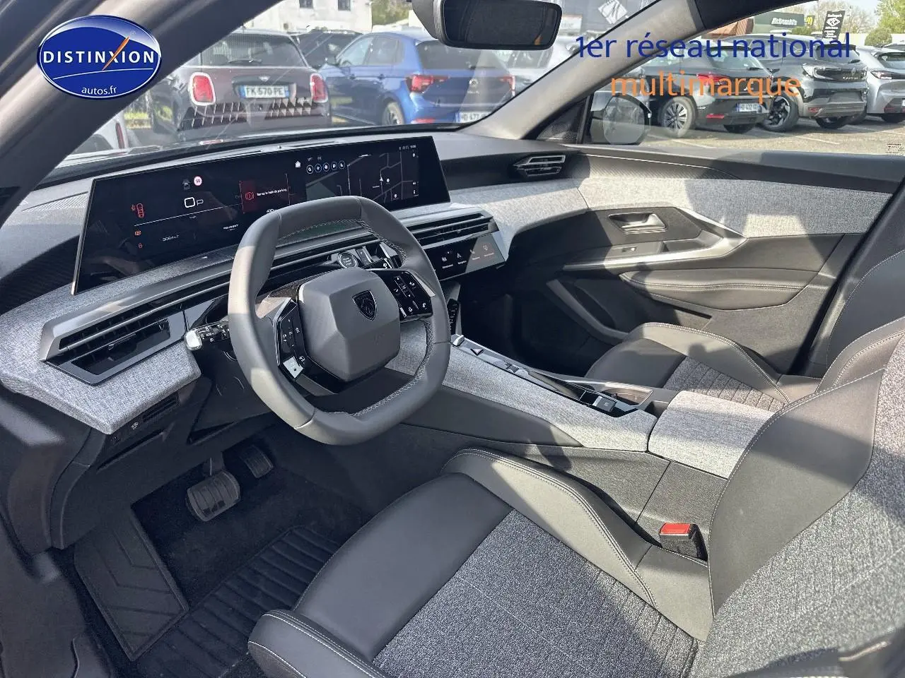 Vue intérieure côté conducteur du Peugeot 3008 2025, tableau de bord moderne avec écran large et sièges bicolores gris et noir.