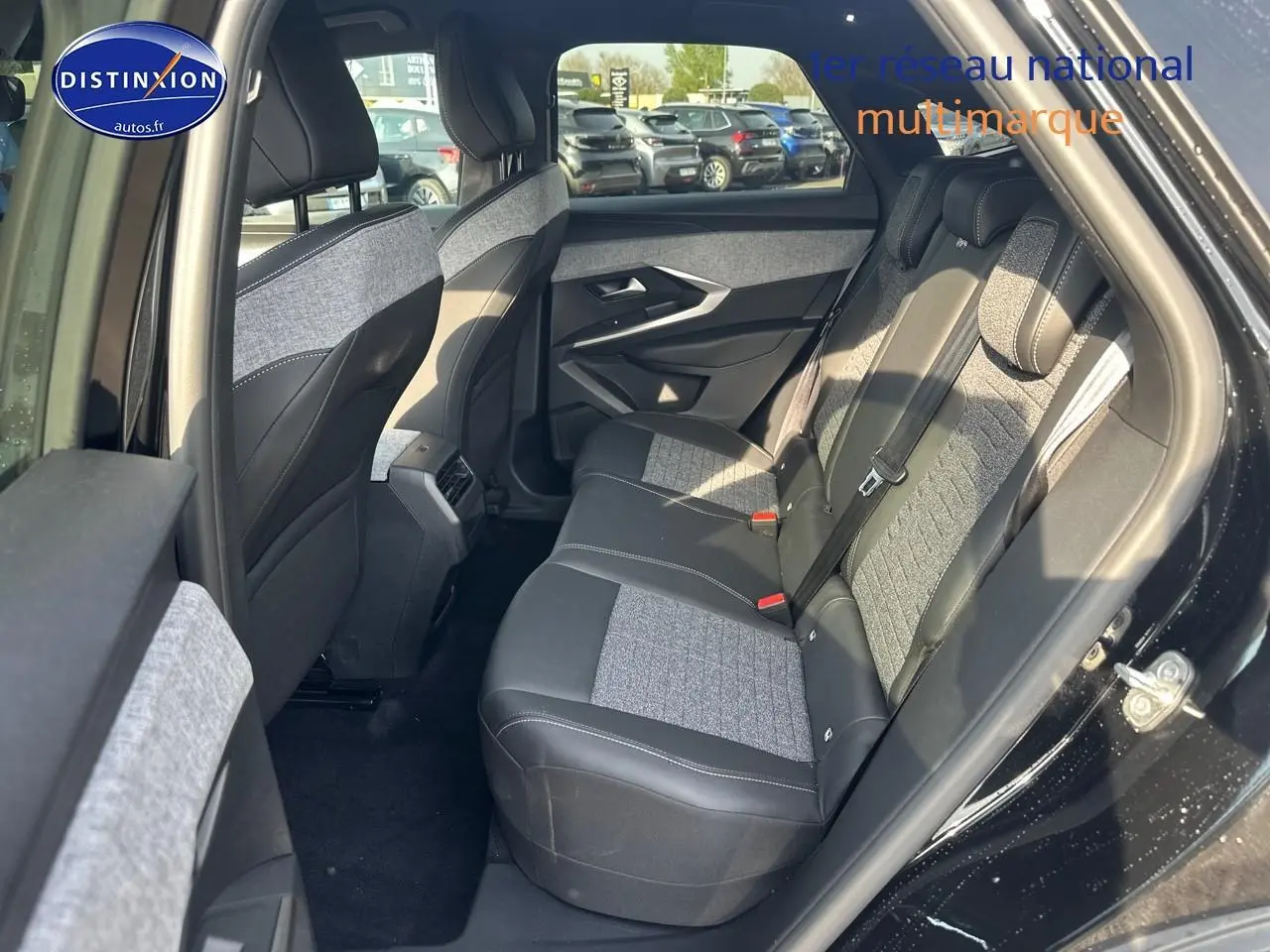Vue côté droit arrière sur l’intérieur noir et gris du Peugeot 3008 1.2 hybrid 145 allure e-dcs6 avec banquette tissu et cuir.