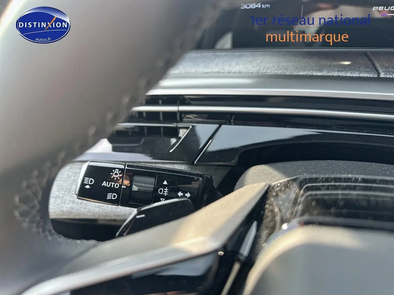 Gros plan sur la commande des phares automatiques côté gauche du volant du Peugeot 3008 noir perla nera 2025.