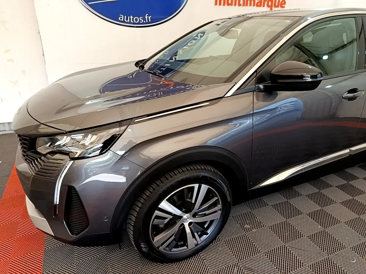 Peugeot 3008 BlueHDi 130 gris foncé en 3/4 avant droit, avec phares LED et jantes alliage visibles.