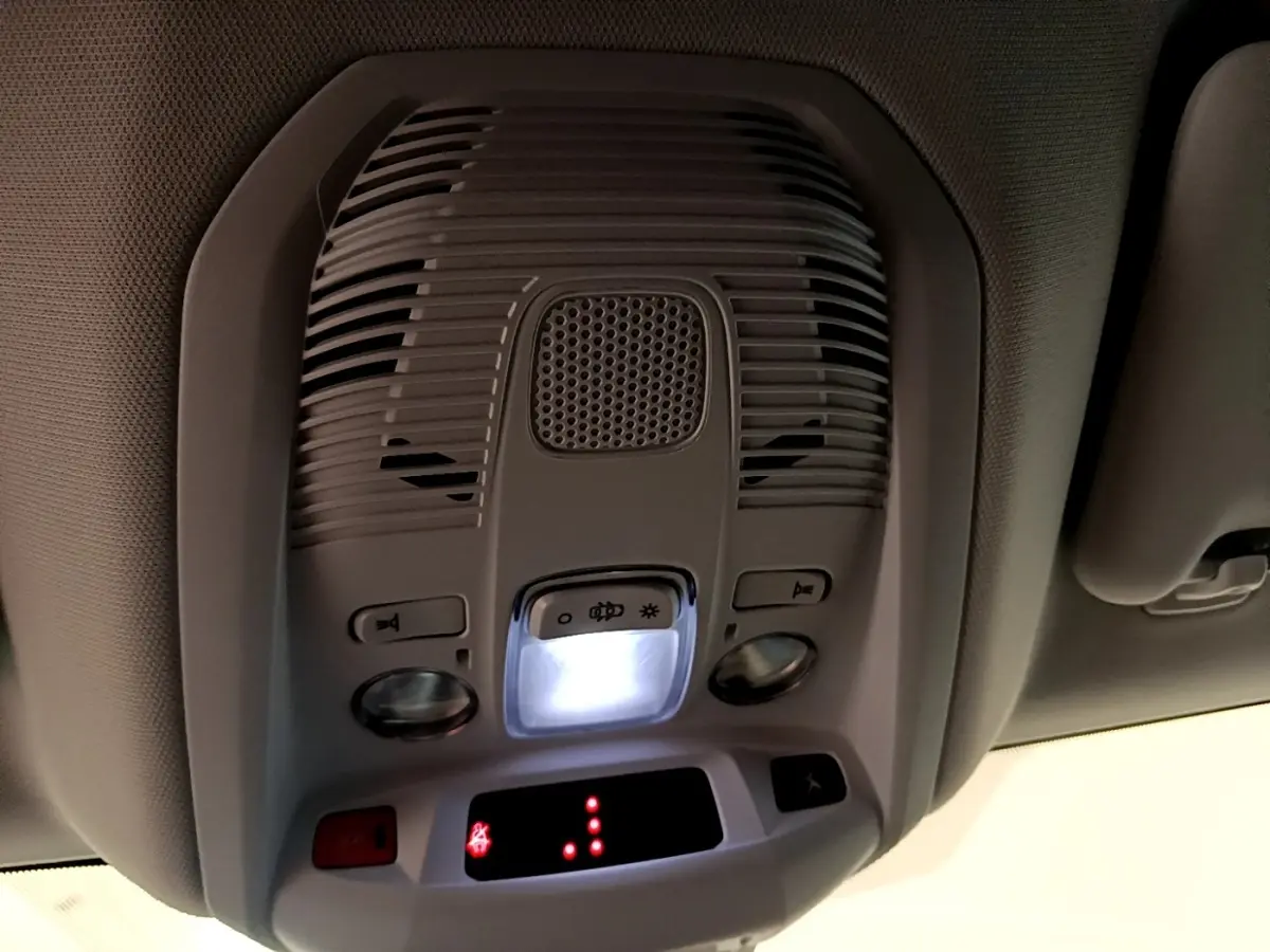 Vue en gros plan du plafonnier intérieur gris clair avec éclairage et commandes dans un Peugeot 3008 gris foncé.