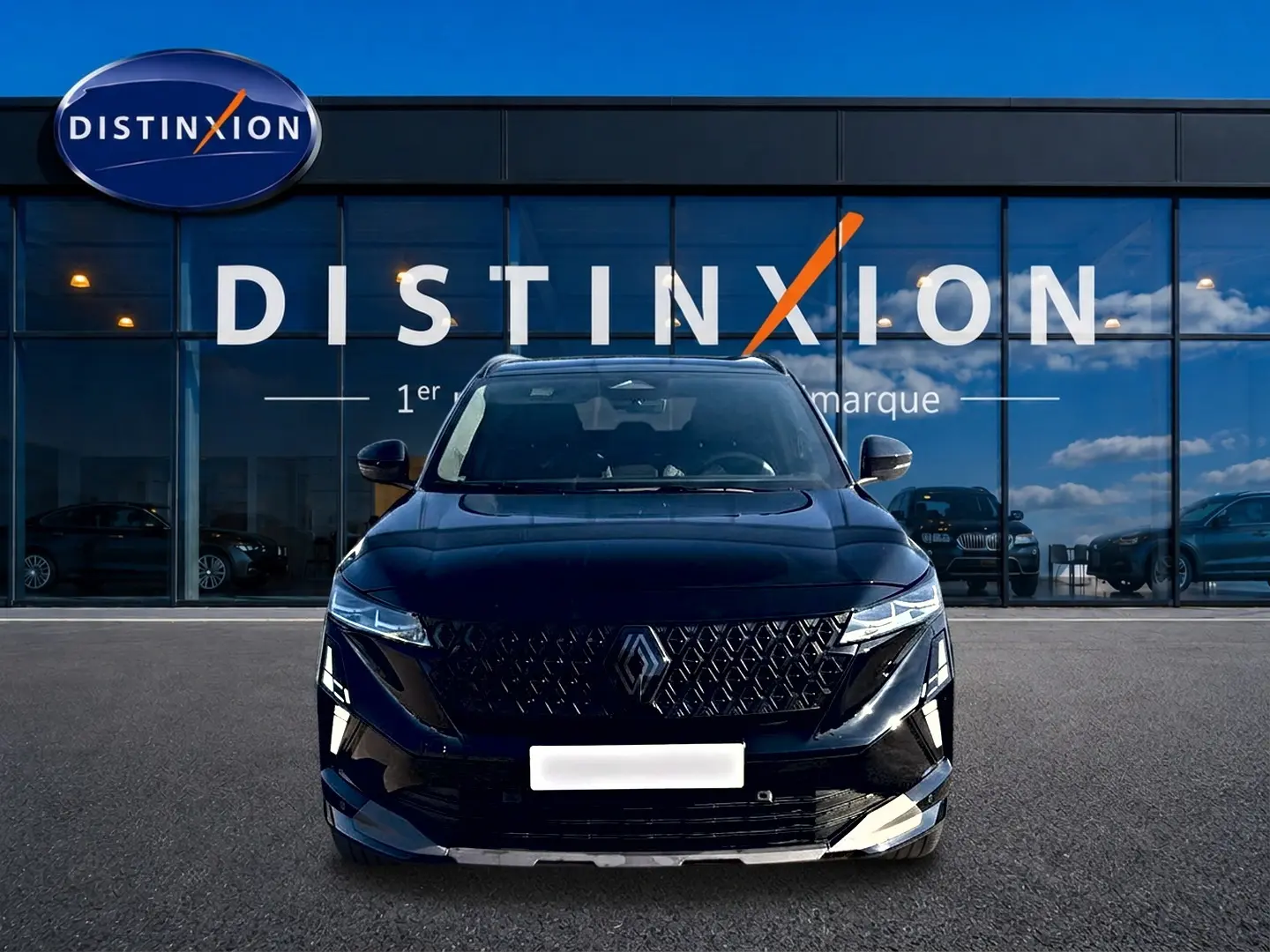 Vue avant du Renault Austral noir avec calandre distinctive et phares LED, devant une vitrine Distinxion.