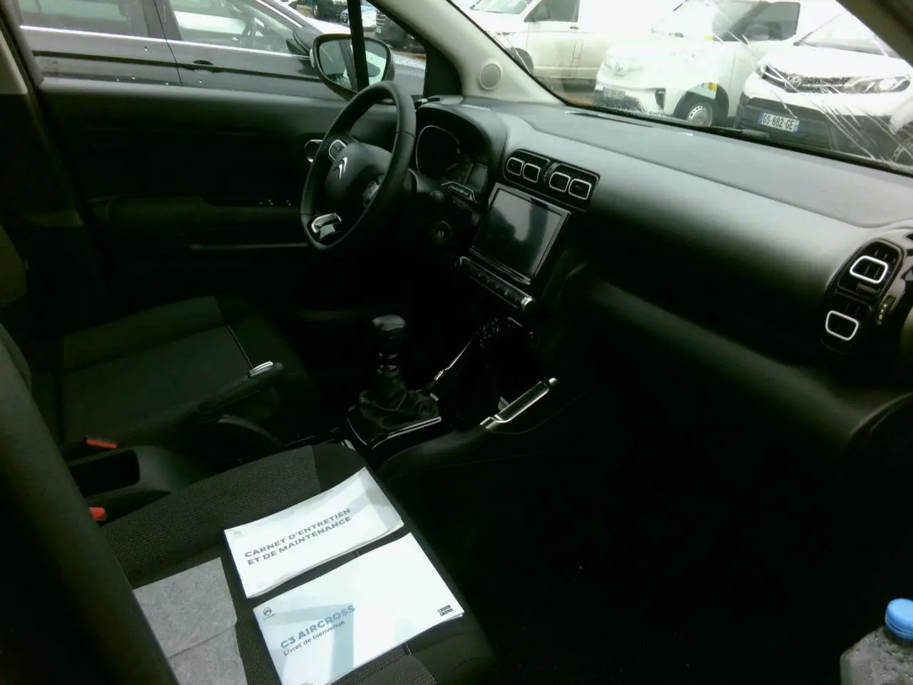 Vue intérieure côté conducteur du Citroën C3 Aircross 2024, tableau de bord noir avec écran tactile central.