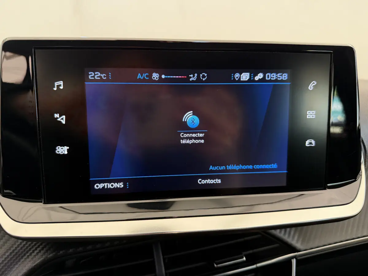 Écran tactile central affichant la connexion Bluetooth dans l'habitacle noir de la Peugeot 208 PureTech 2021.