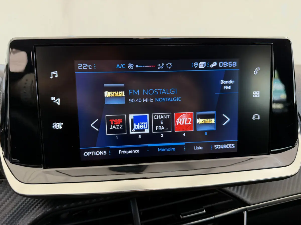 Écran tactile central de la Peugeot 208 2021 affichant les stations radio FM avec interface moderne et boutons tactiles.