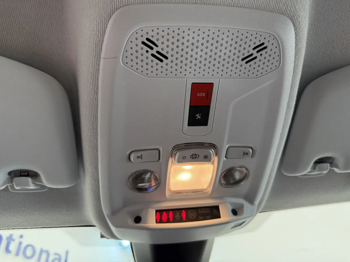 Plafonnier intérieur avec bouton SOS et éclairage, vue du toit d'une Peugeot 208 noire 2021 PureTech.