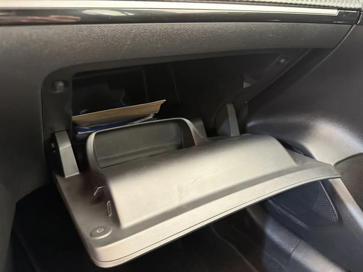 Gant de boîte à gants ouvert côté passager avec documents, intérieur noir de la Peugeot 208 PureTech 2021.