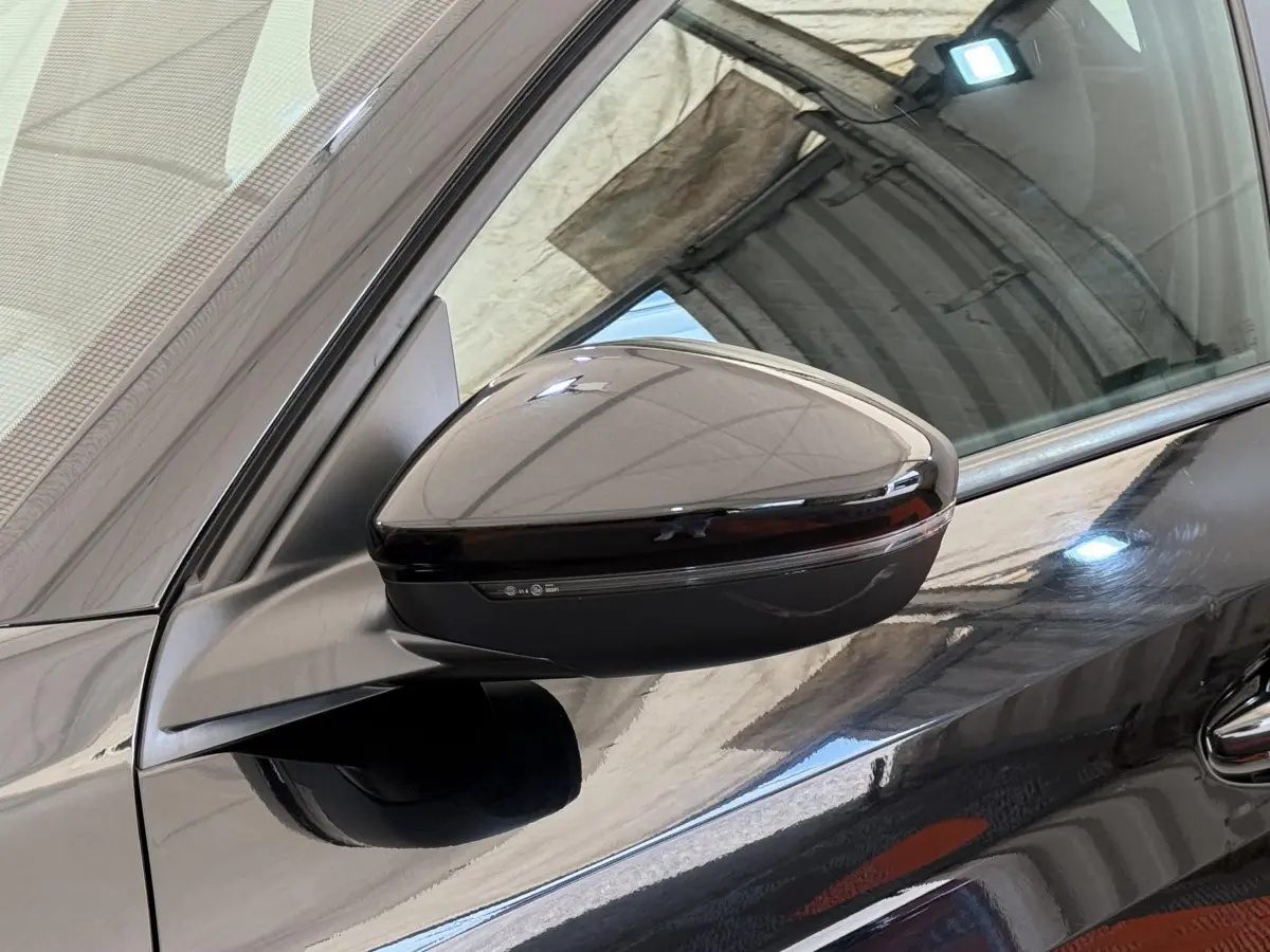Gros plan sur le rétroviseur côté gauche noir brillant d'une Peugeot 208 PureTech 100 de 2021.
