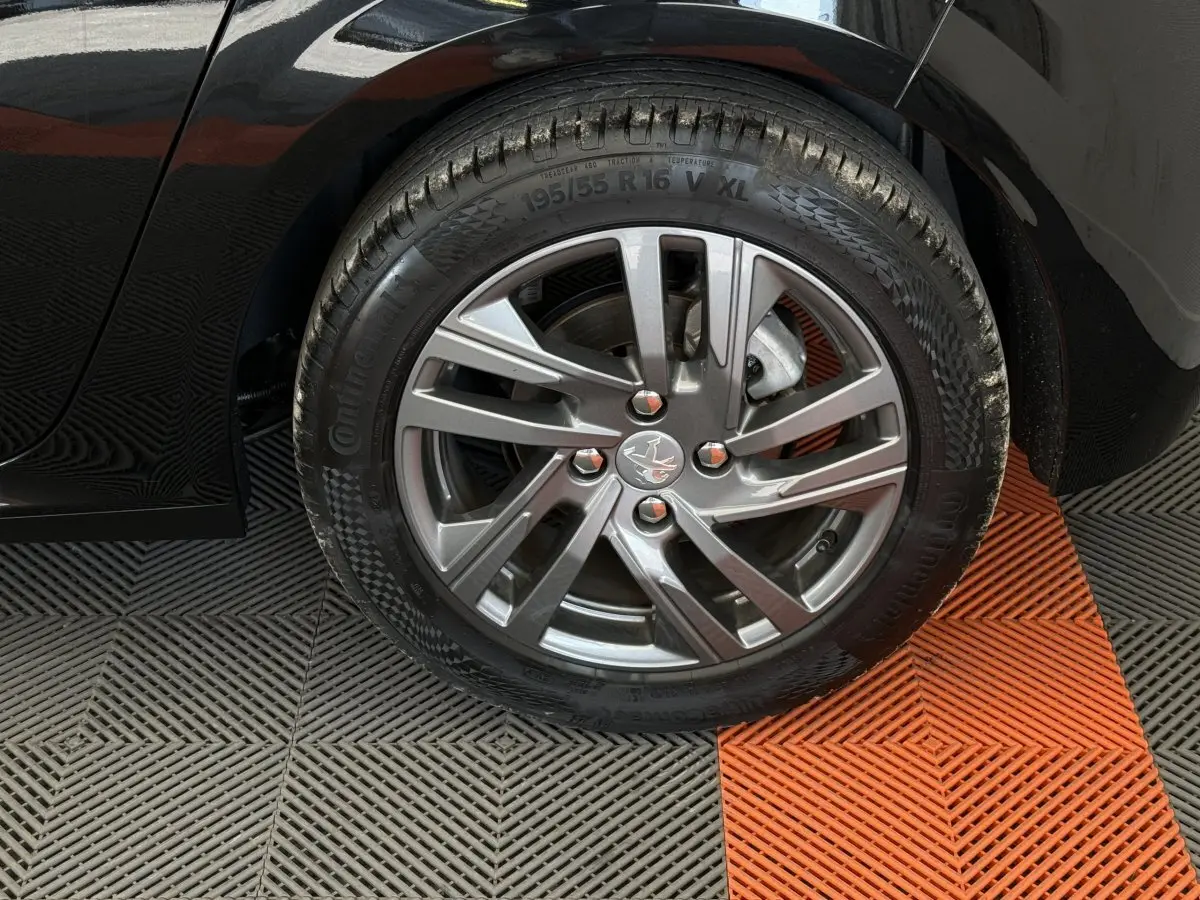 Gros plan sur la roue avant droite noire de la Peugeot 208 2021 avec jante alliage et pneu Continental.