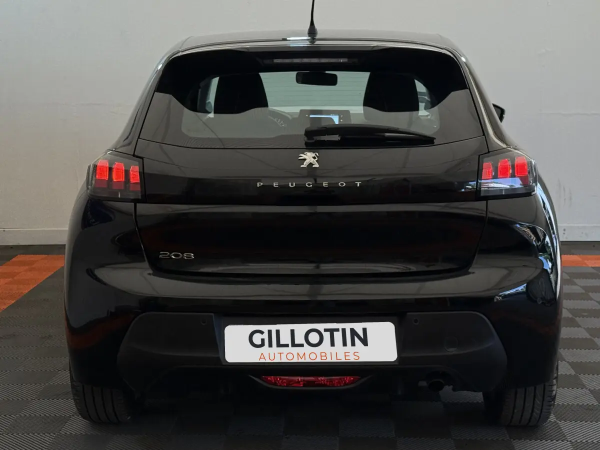 Vue arrière d'une Peugeot 208 noire avec feux arrière LED et logo Peugeot bien visibles sur fond neutre.