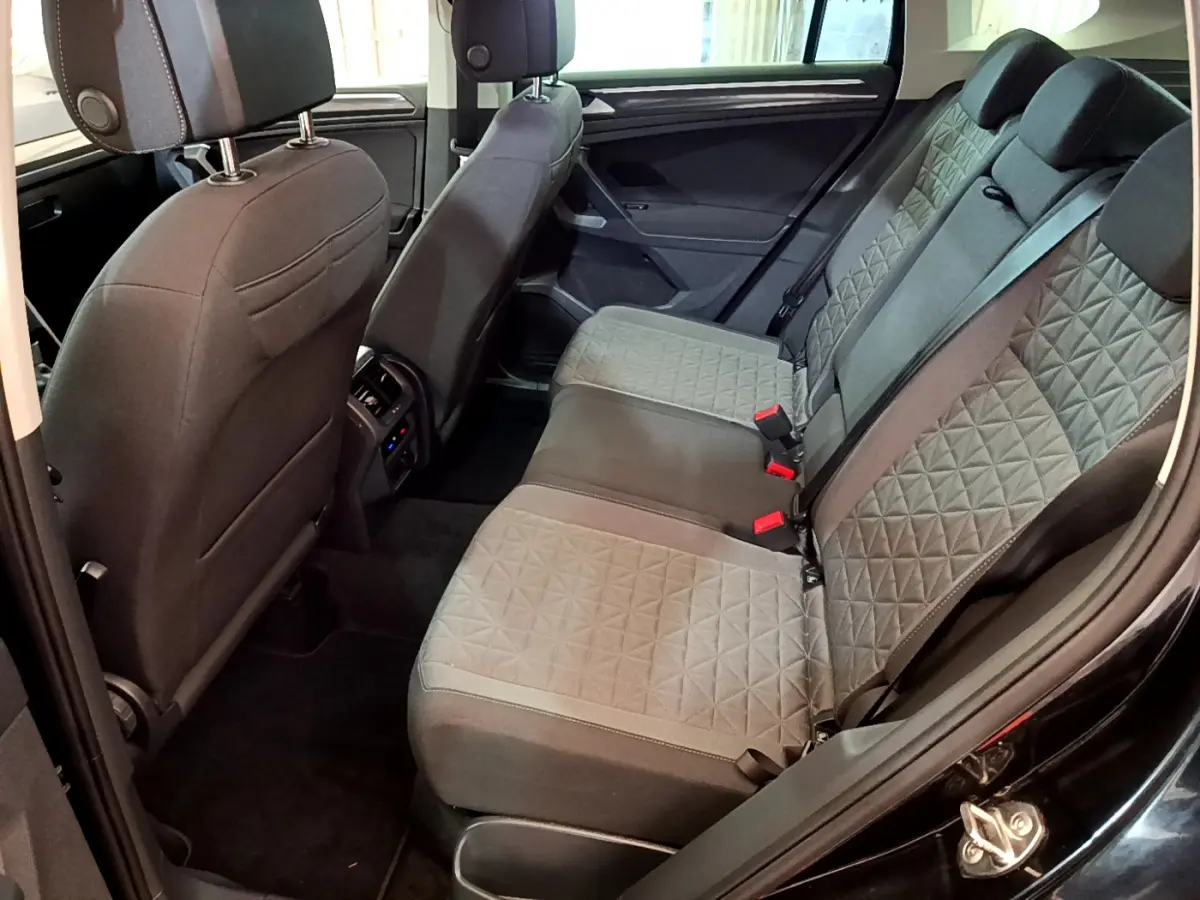 Vue intérieure arrière côté droit du Volkswagen Tiguan 2.0 TDI noir, sièges arrière en tissu gris à motifs géométriques.