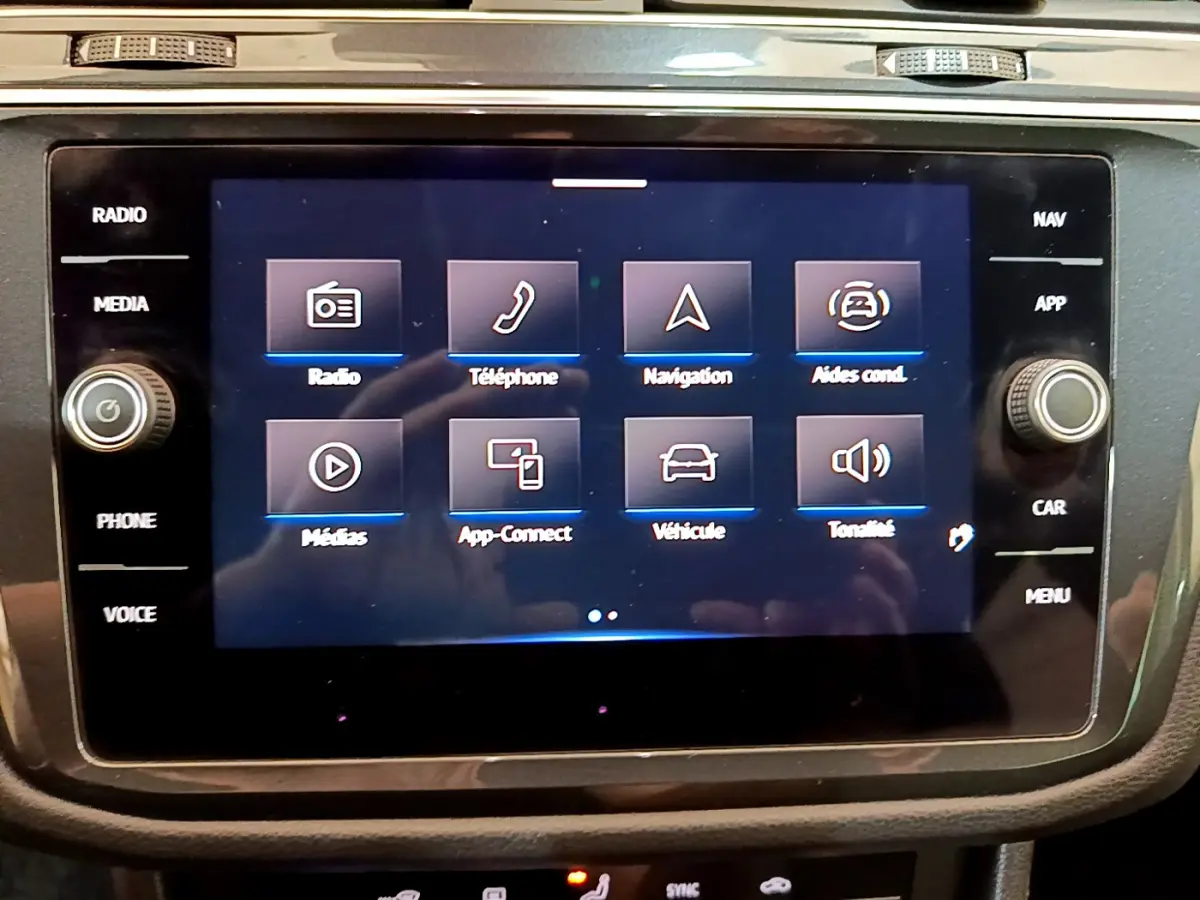 Écran tactile central du tableau de bord du Volkswagen Tiguan 2.0 TDI noir, affichant les options multimédia et navigation.