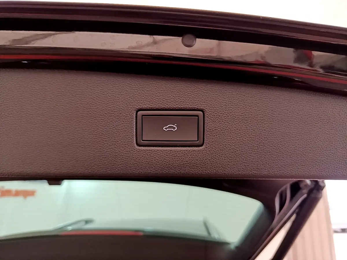 Bouton de fermeture électrique du coffre sur la partie intérieure du hayon d'un Volkswagen Tiguan noir.