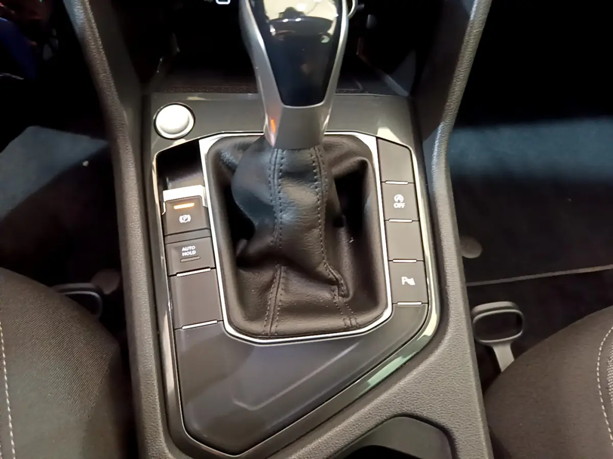 Gros plan sur la console centrale noire du Volkswagen Tiguan 2.0 TDI avec levier de vitesses automatique et boutons fonctionnels.