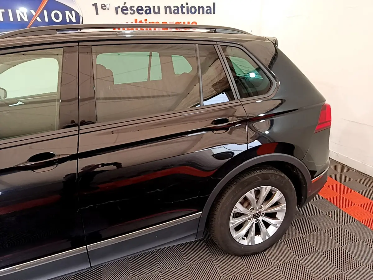 Vue latérale côté gauche d'un Volkswagen Tiguan noir 2.0 TDI 150 DSG7 Life Business avec jantes alliage.