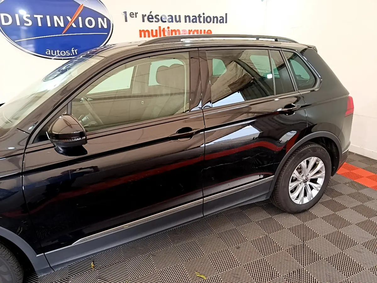 Vue latérale côté gauche d'un Volkswagen Tiguan noir 2021, avec jantes alliage et rétroviseur noir brillant.