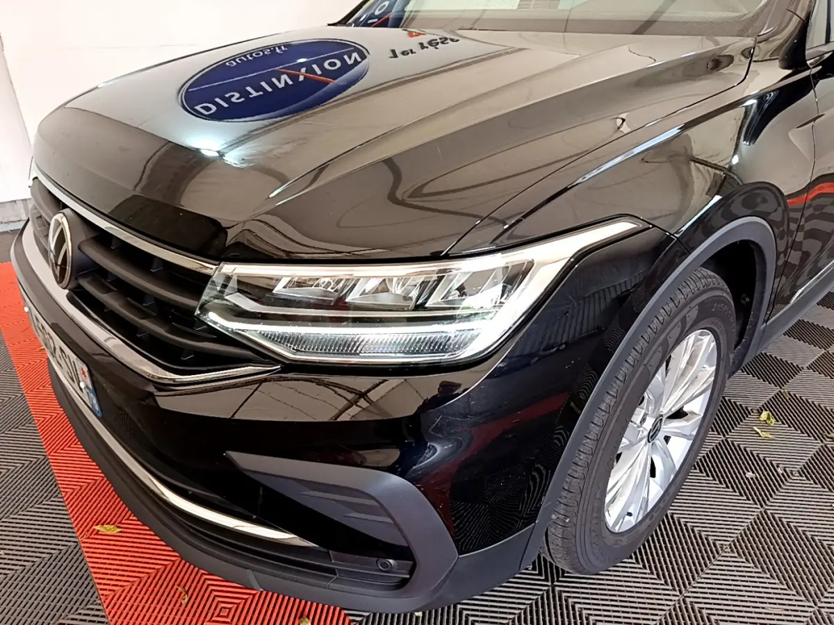 Vue 3/4 avant droit du Volkswagen Tiguan noir 2021 avec phares LED et jantes alliage visibles.