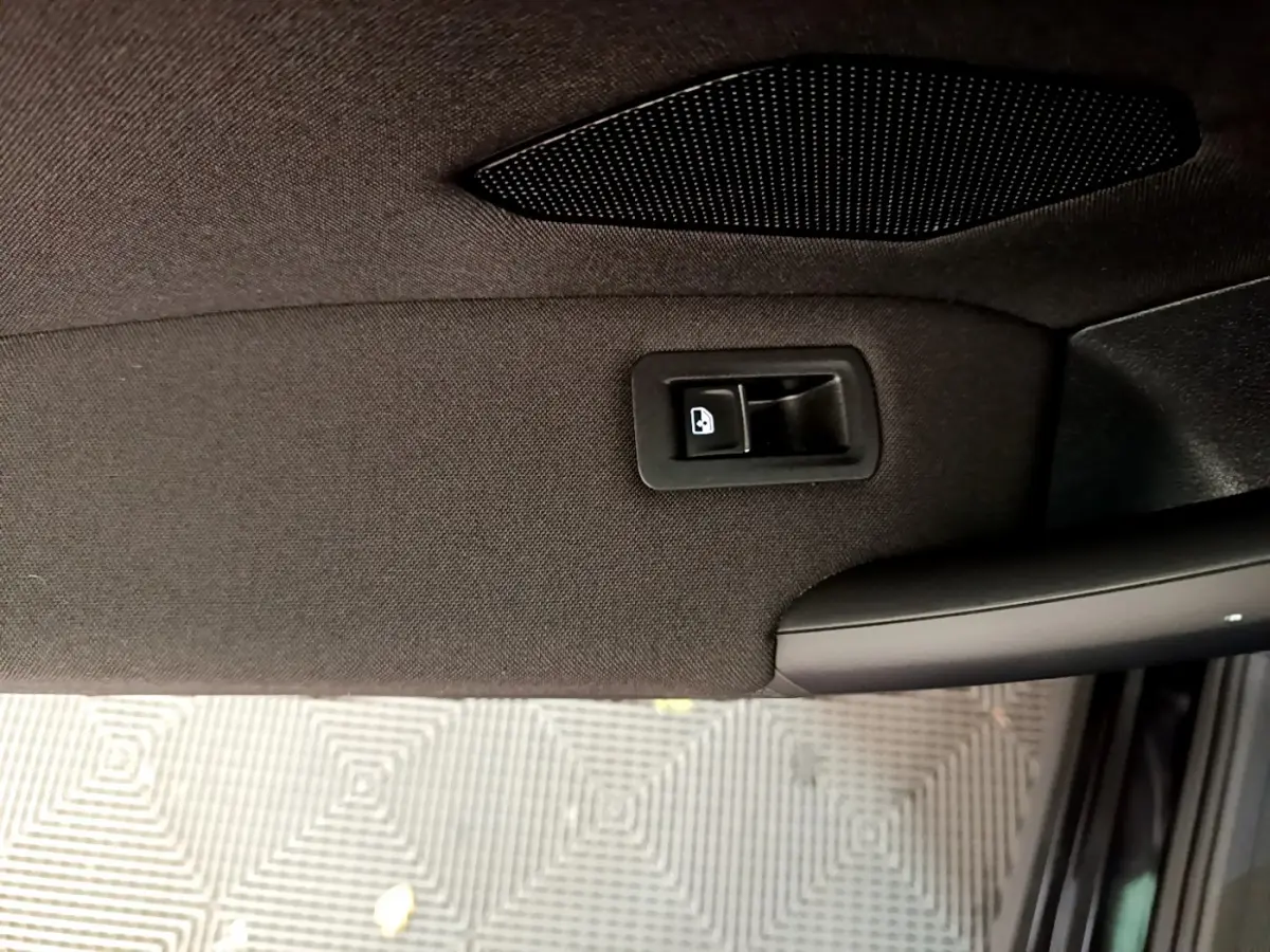 Poignée de déverrouillage de porte arrière côté droit du Volkswagen Tiguan noir, vue intérieure rapprochée.
