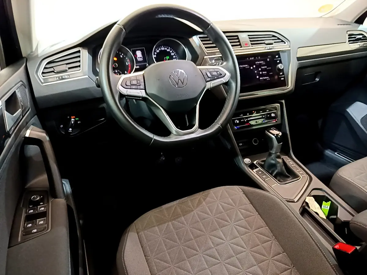 Intérieur du Volkswagen Tiguan 2021 en vue avant centrée sur le volant cuir et la console centrale avec écran tactile.