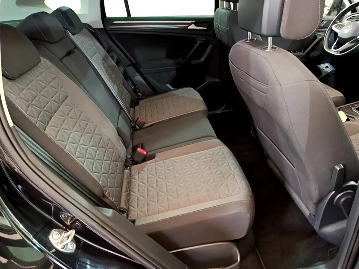 Vue intérieure côté gauche sur la banquette arrière grise au tissu matelassé du Volkswagen Tiguan noir 2021.