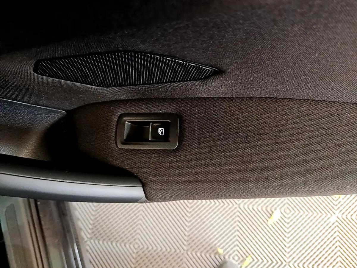 Détail de la commande de lève-vitre sur la portière intérieure côté conducteur du Volkswagen Tiguan noir 2021.