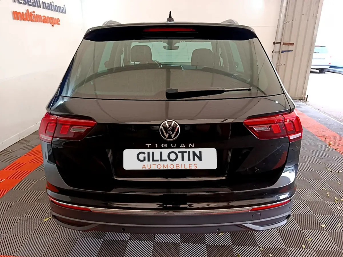 Vue arrière d'un Volkswagen Tiguan noir 2021 avec feux LED et logo VW visible sur le hayon.