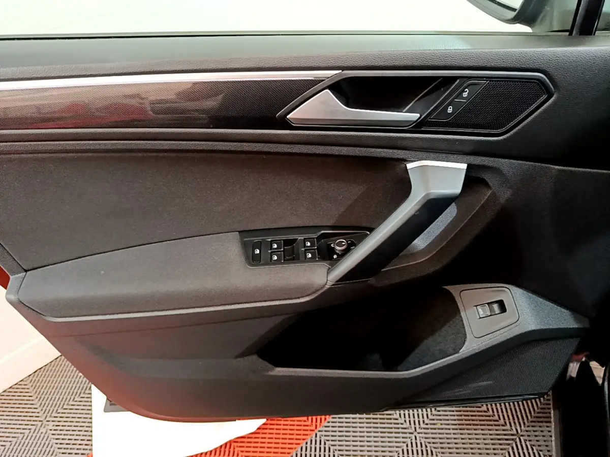 Vue rapprochée de la porte avant gauche noire du Volkswagen Tiguan 2.0 TDI 150 DSG7 Life Business avec commandes électriques.