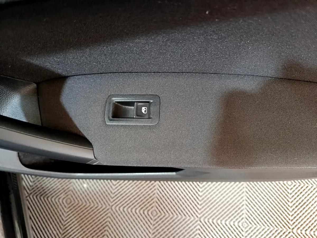 Bouton de verrouillage de porte sur la garniture intérieure noire de la porte côté gauche d'un Volkswagen Tiguan 2021.