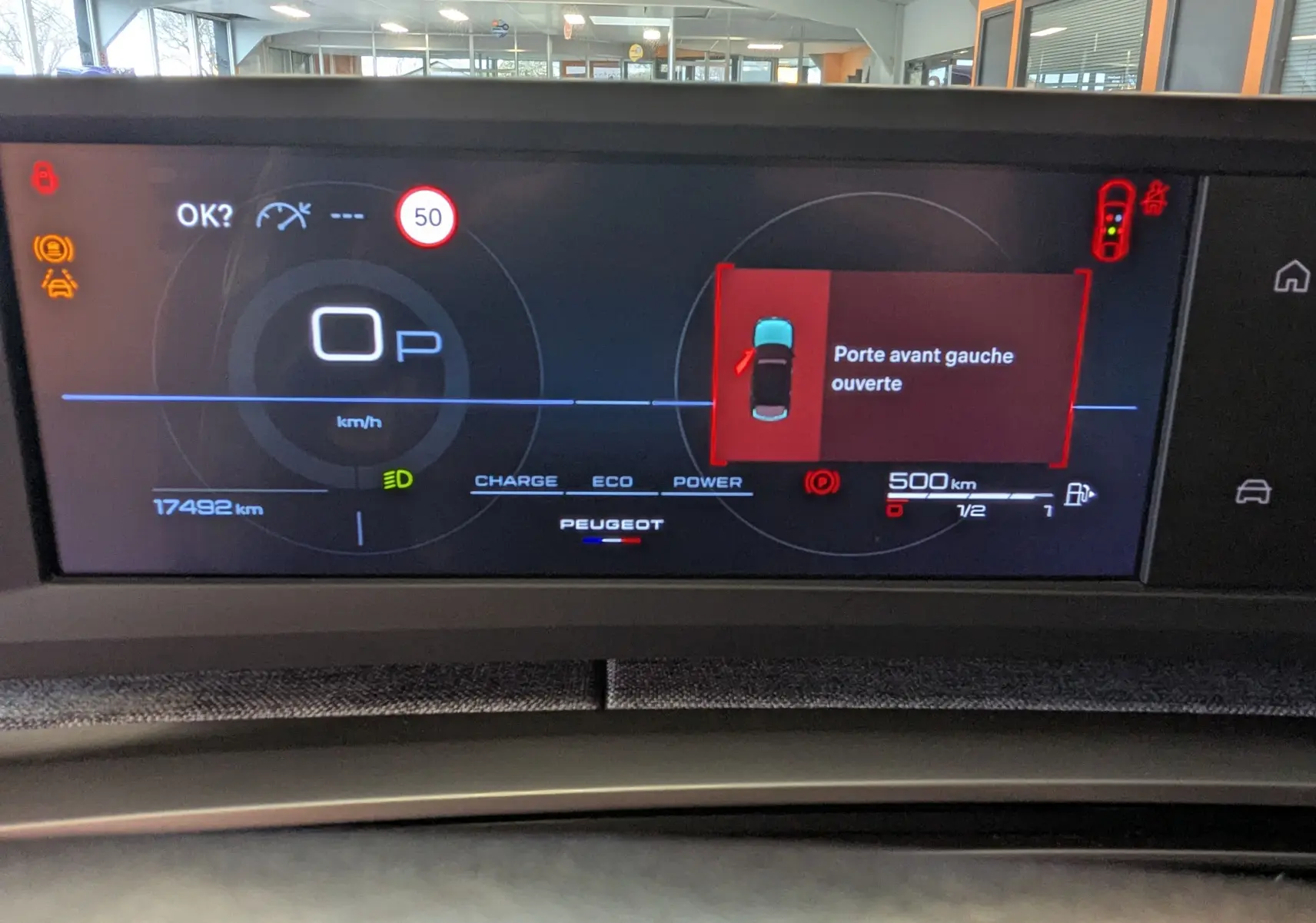 Tableau de bord numérique du Peugeot 3008 Hybrid blanc, affichant porte avant gauche ouverte et vitesse à 0 km/h.