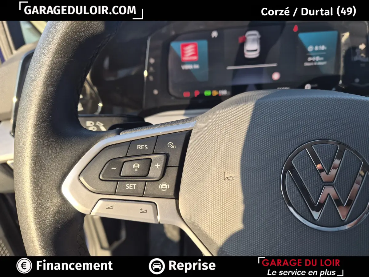 Gros plan sur le volant cuir gris de la Volkswagen Golf 2023 avec commandes multifonctions et logo VW central.