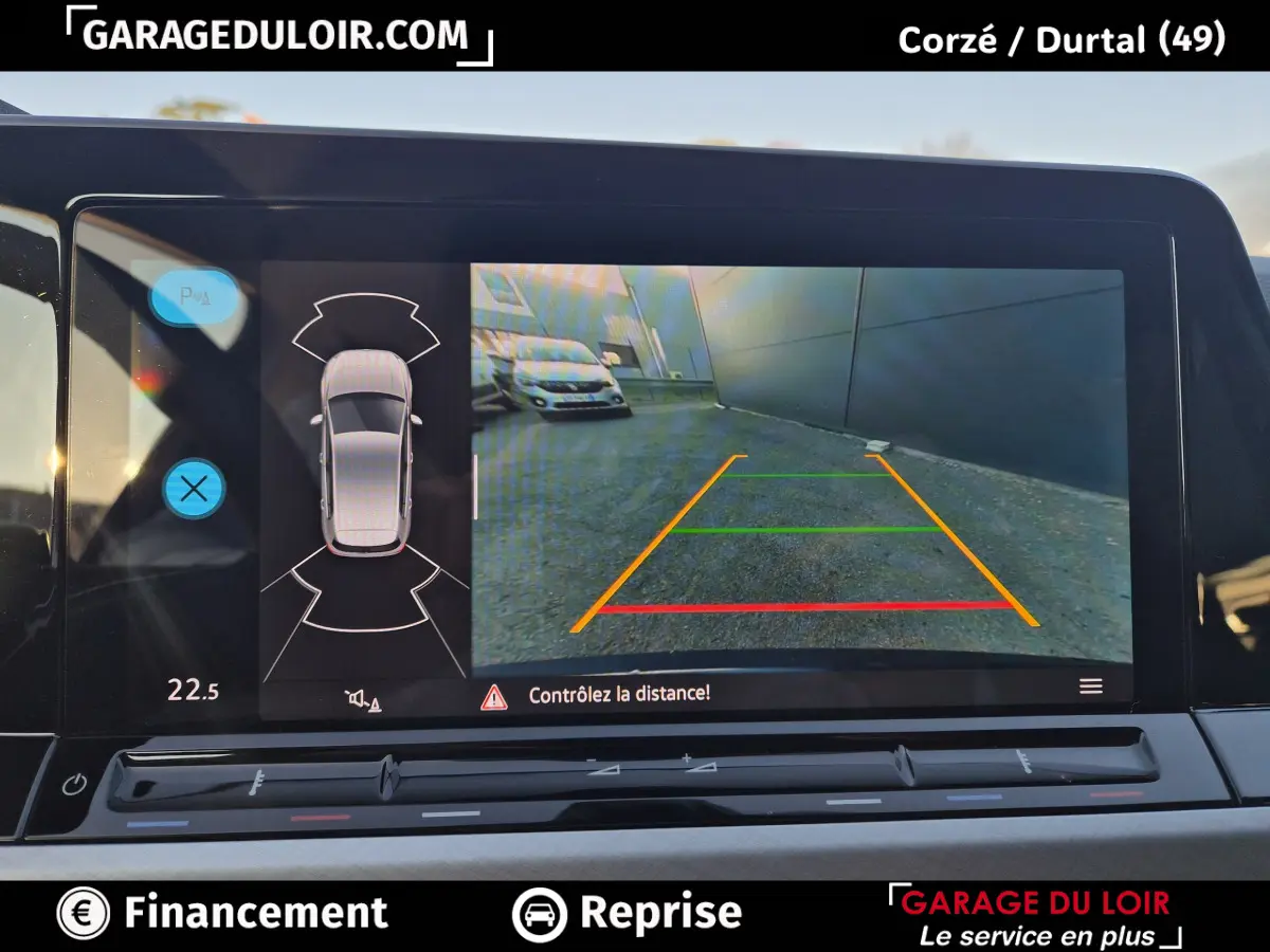 Écran de caméra de recul avec vue arrière et capteurs de distance sur Volkswagen Golf bleu 2023.