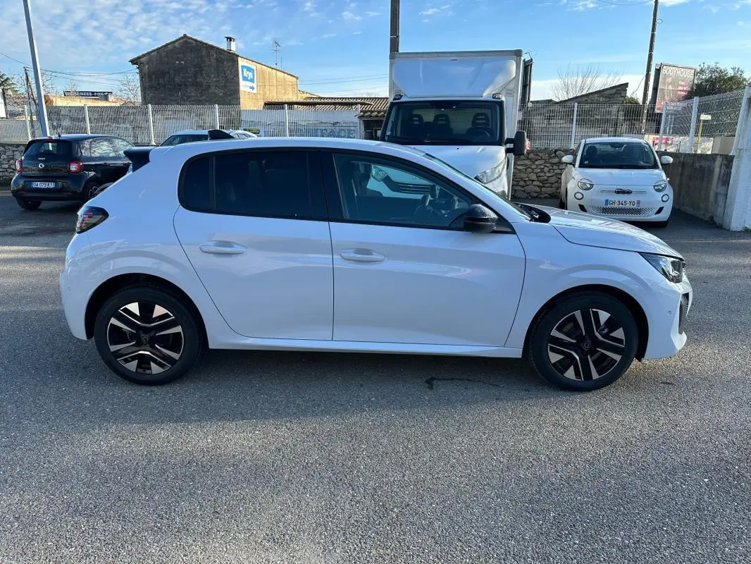 Peugeot 208 Hybrid blanc vue de profil côté gauche, avec jantes alliage noires et toit noir contrasté.
