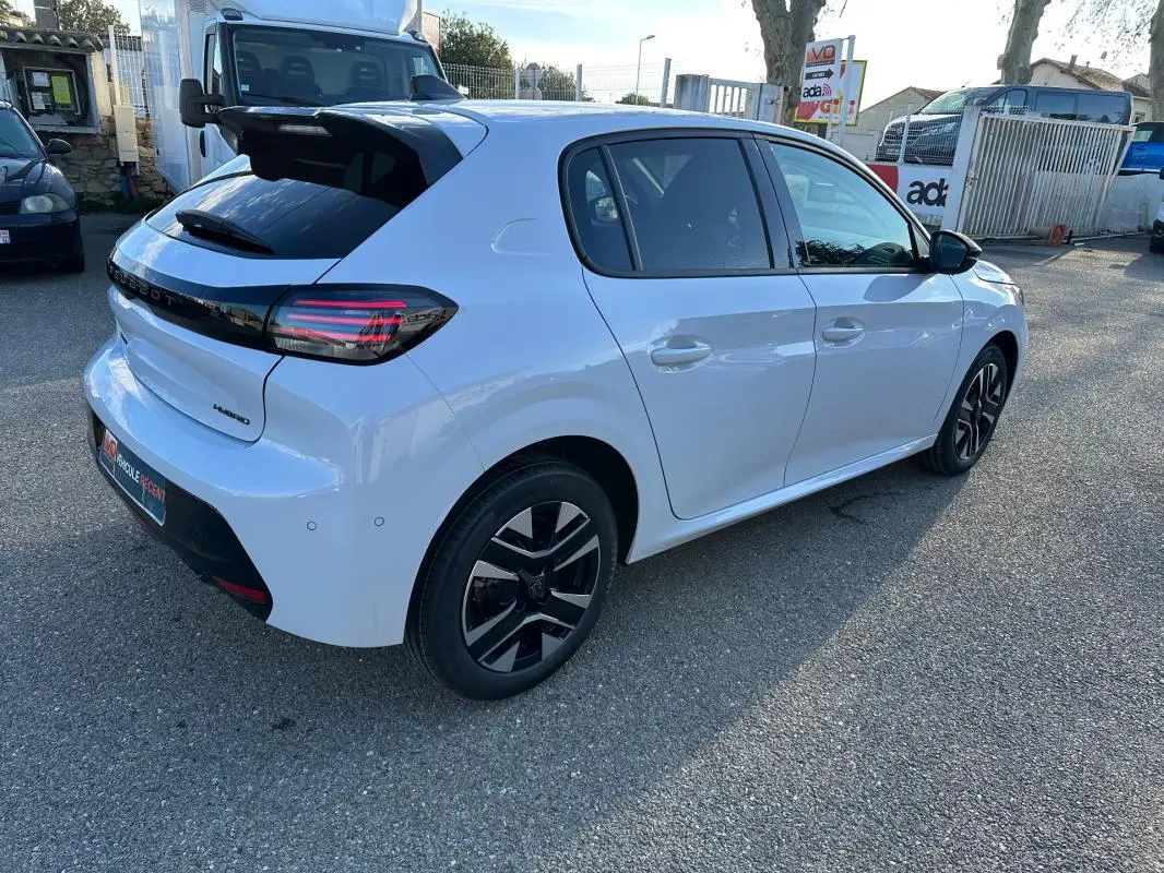 Peugeot 208 Hybrid blanc vue 3/4 arrière droit, jantes alliage 16 pouces et feux arrière LED distinctifs.