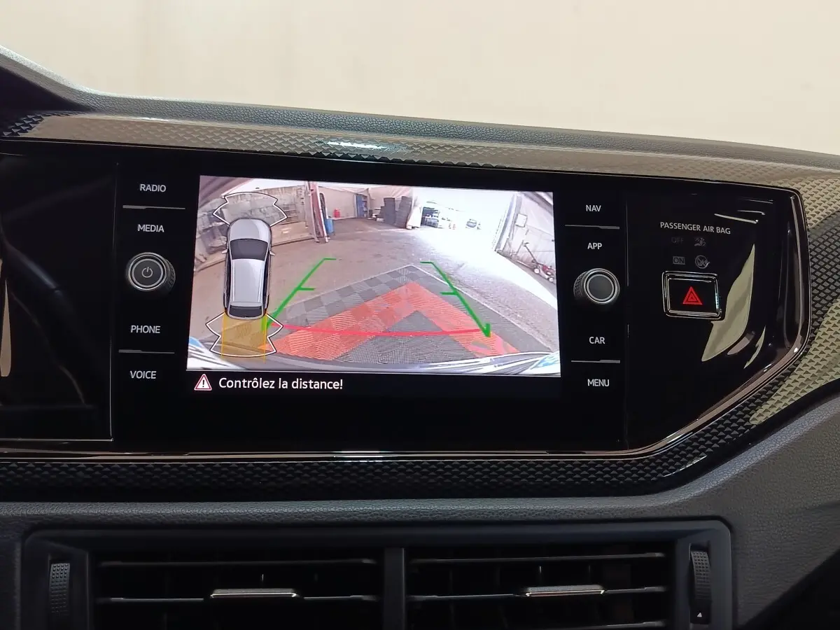 Écran tactile central du Volkswagen Taigo 2023 affichant l'aide au stationnement arrière avec guidage visuel couleur.