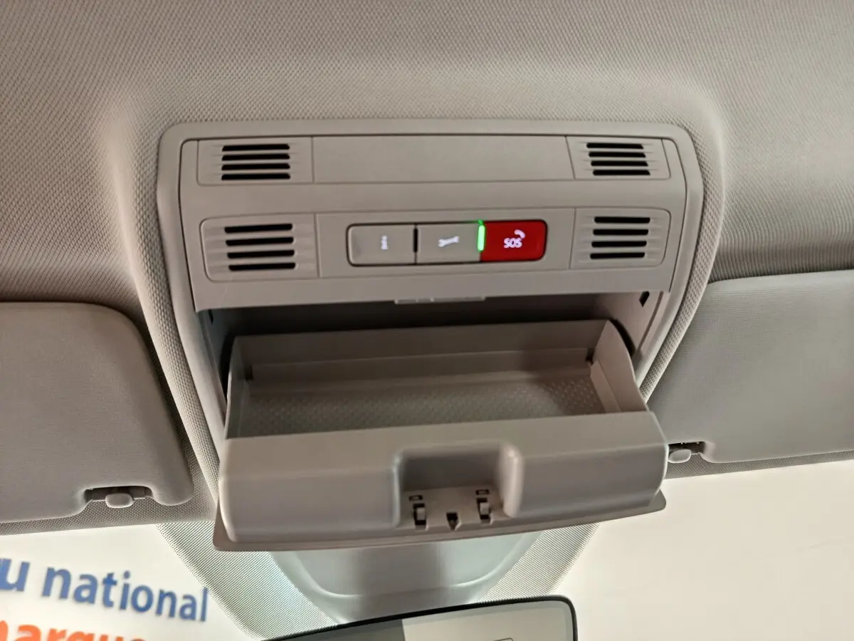 Vue intérieure du plafond avant du Volkswagen Taigo 2023, avec rangement ouvert et boutons SOS visibles en gris clair.
