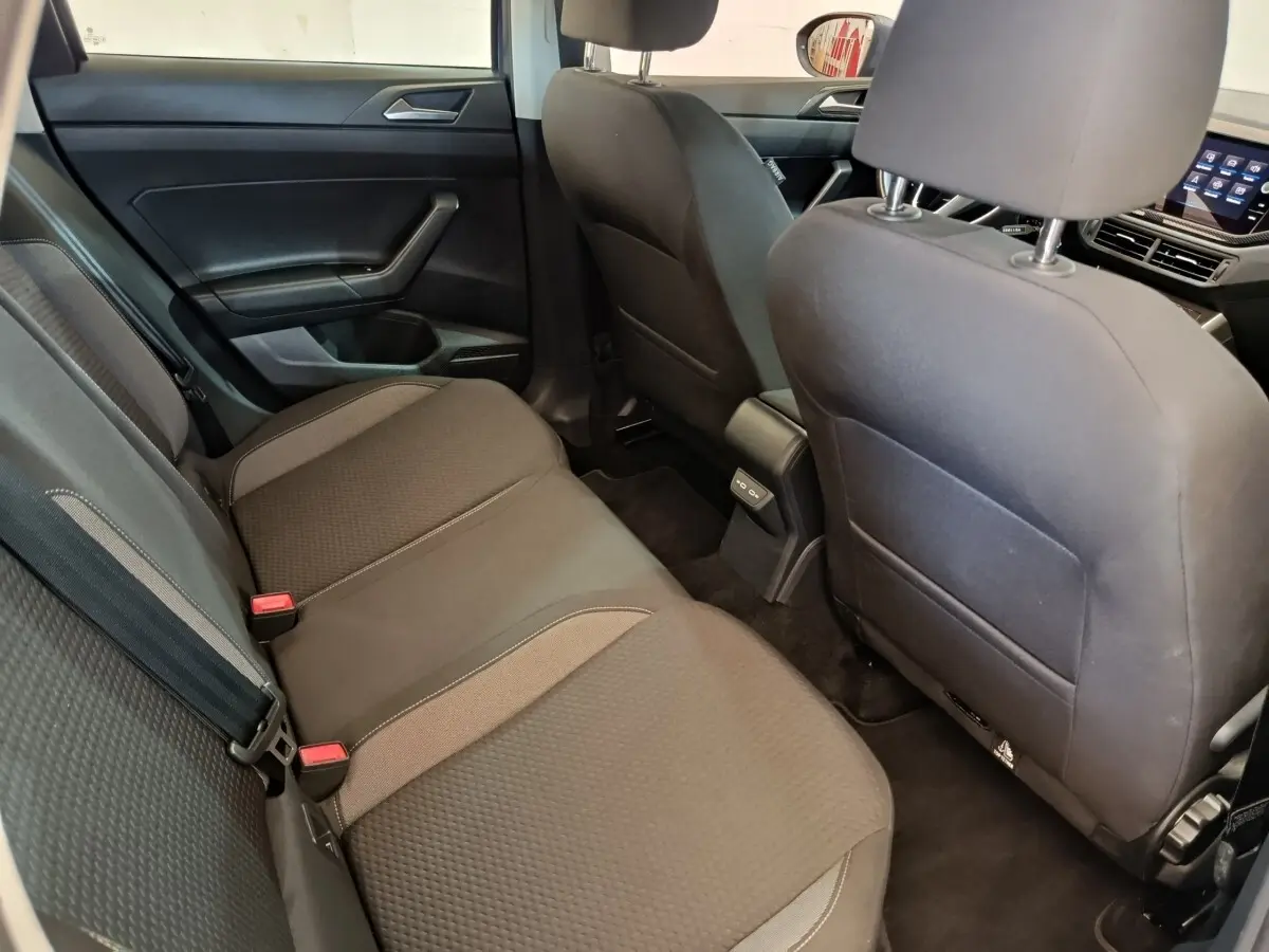 Vue intérieure arrière côté gauche du Volkswagen Taigo 1.0 TSI 110 DSG Life Plus 2023, sièges tissu gris foncé.