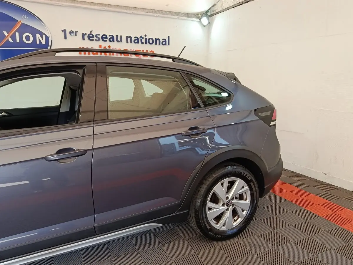Vue latérale droite du Volkswagen Taigo gris foncé 2023, mettant en valeur la porte arrière et la roue arrière.