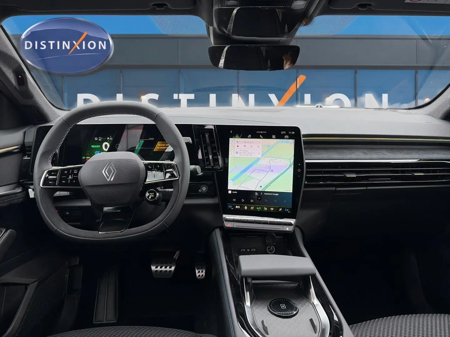 Vue intérieure frontale du tableau de bord du Renault Austral gris schiste avec écran tactile vertical et volant multifonction.