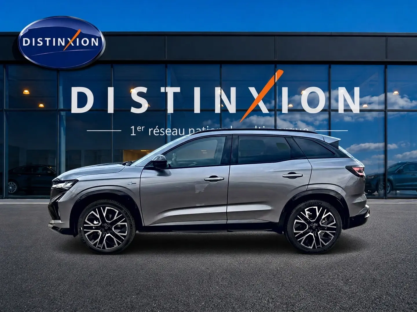 Profil droit du Renault Austral gris schiste 2026 avec jantes alu et toit noir devant une vitrine Distinxion.