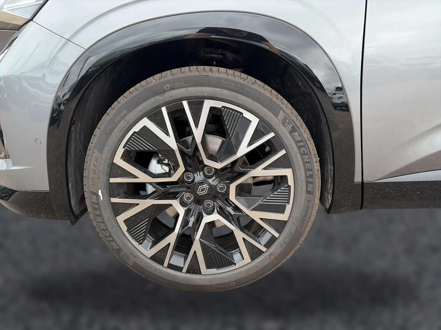 Gros plan sur la roue avant droite du Renault Austral gris schiste avec jante alliage au design géométrique noir et argent.