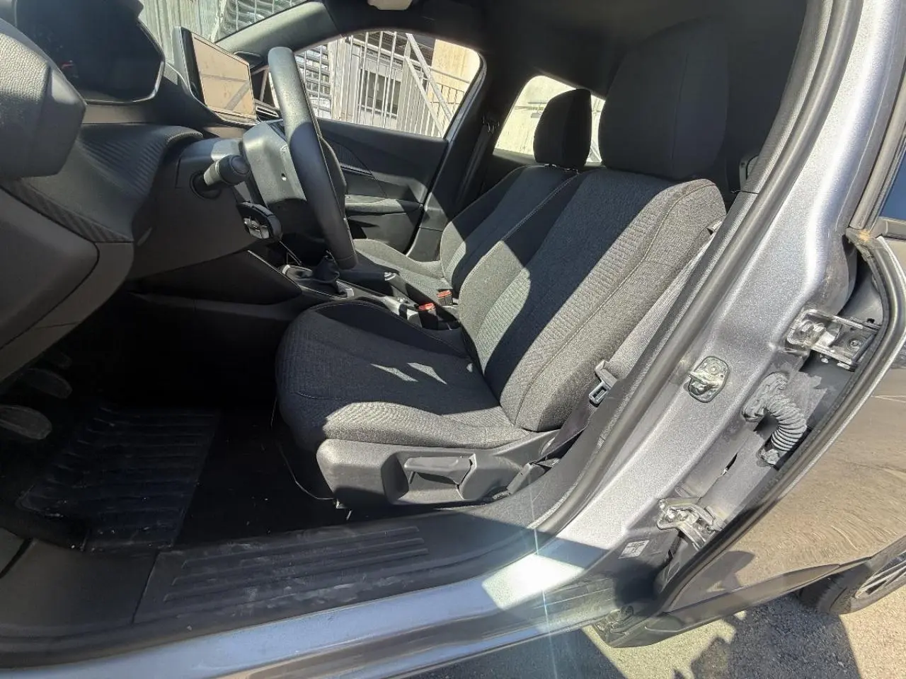 Intérieur côté conducteur du Peugeot 2008 2025 artense, montrant les sièges tissu gris et la boîte manuelle.
